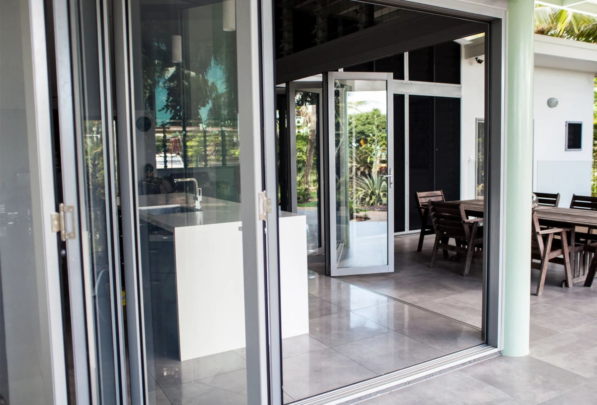 Window Works NT — custom aluminium bi-fold doors opening to an outdoor entertaining area in Darwin