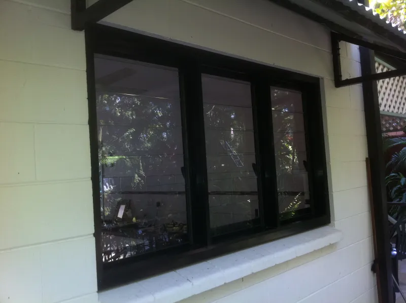 Exterior sliding windows with dark frames on a residential property
